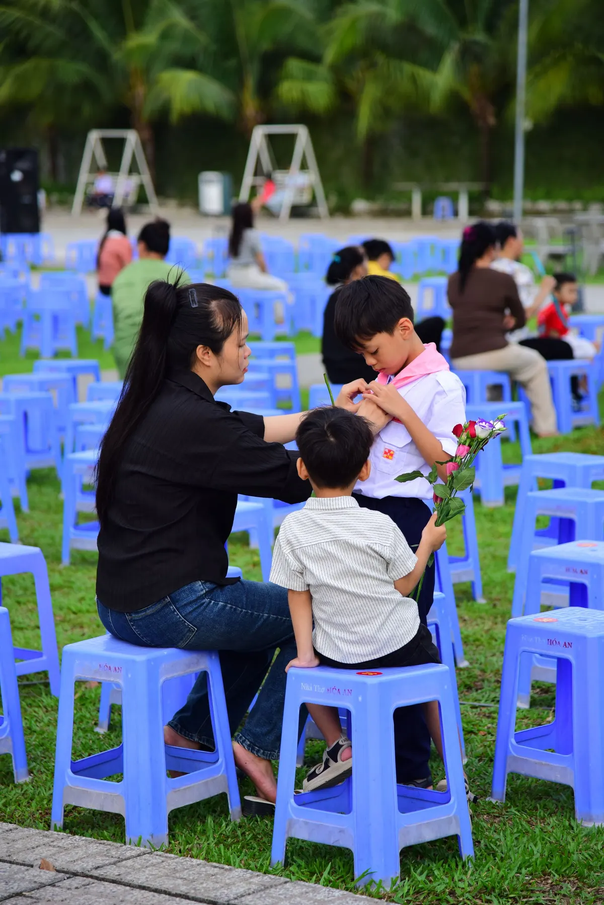 A mother sitting outdoors in a park with her children